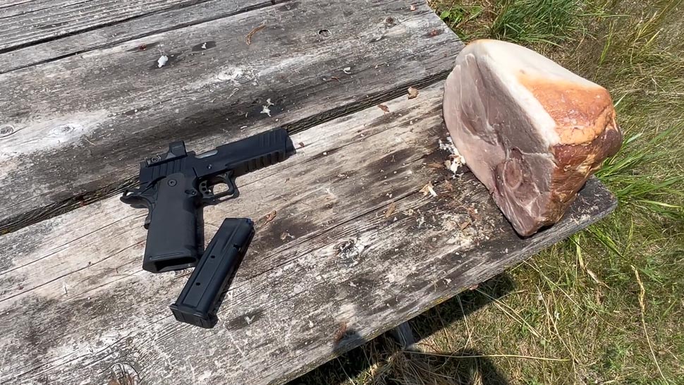 A 9mm Handgun and Piece of Ham on The Table, Ready for The Ammo-Power Test