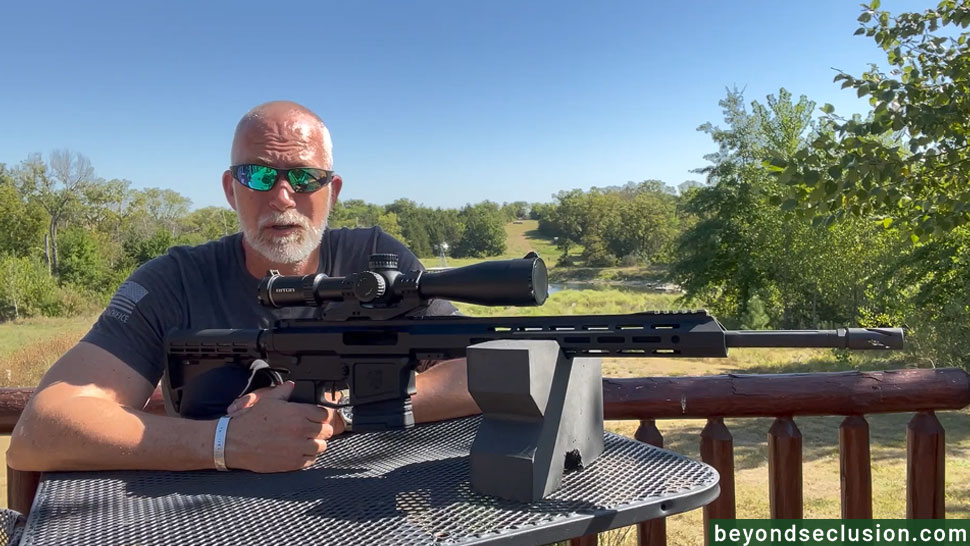 A Man at The Table Is Posing with The BCA 308 AR10 Rifle