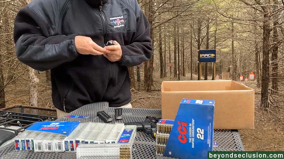 A Man Is Reloading a Couple of Gun Magazines